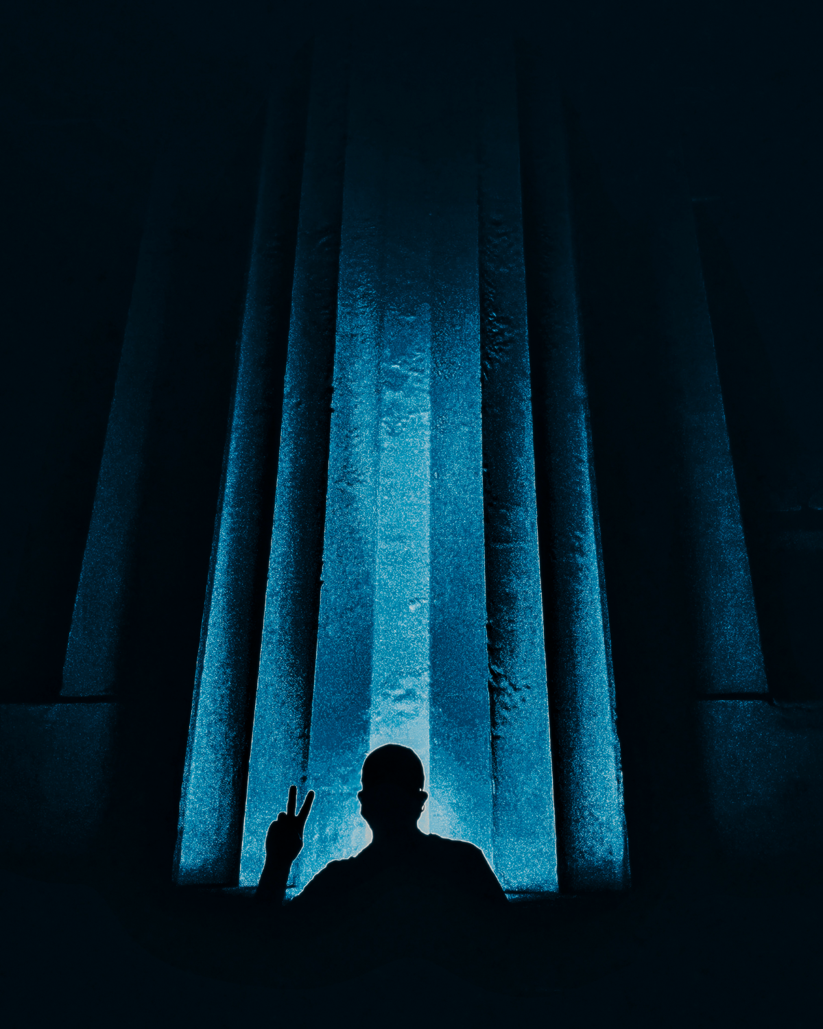 Silhouette among illuminated blue vertical columns