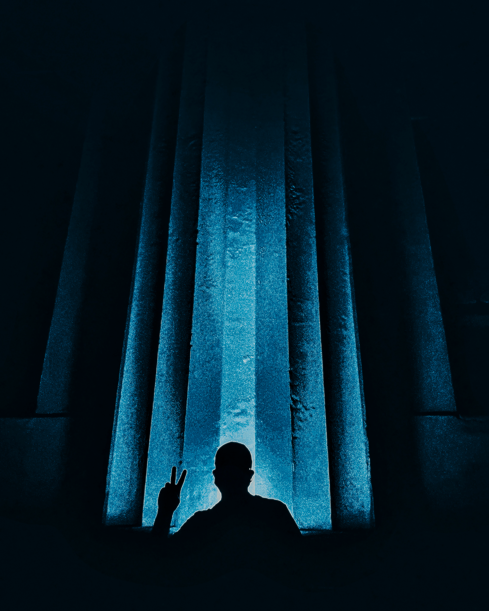 Silhouette among illuminated blue vertical columns