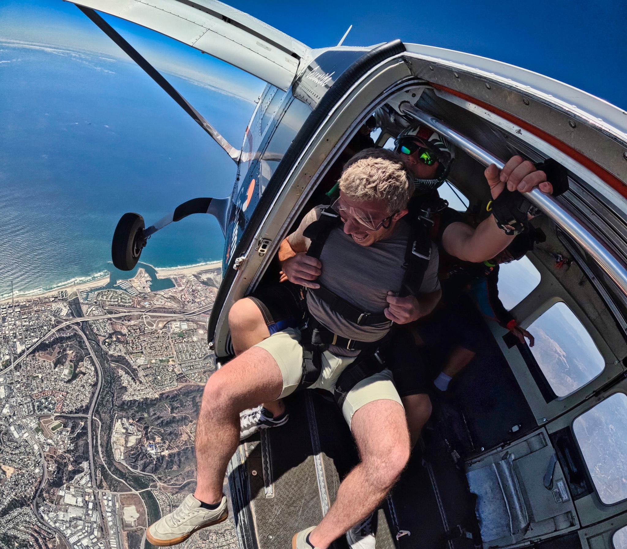 View from the open door of a plane over the California coastline during a skydive