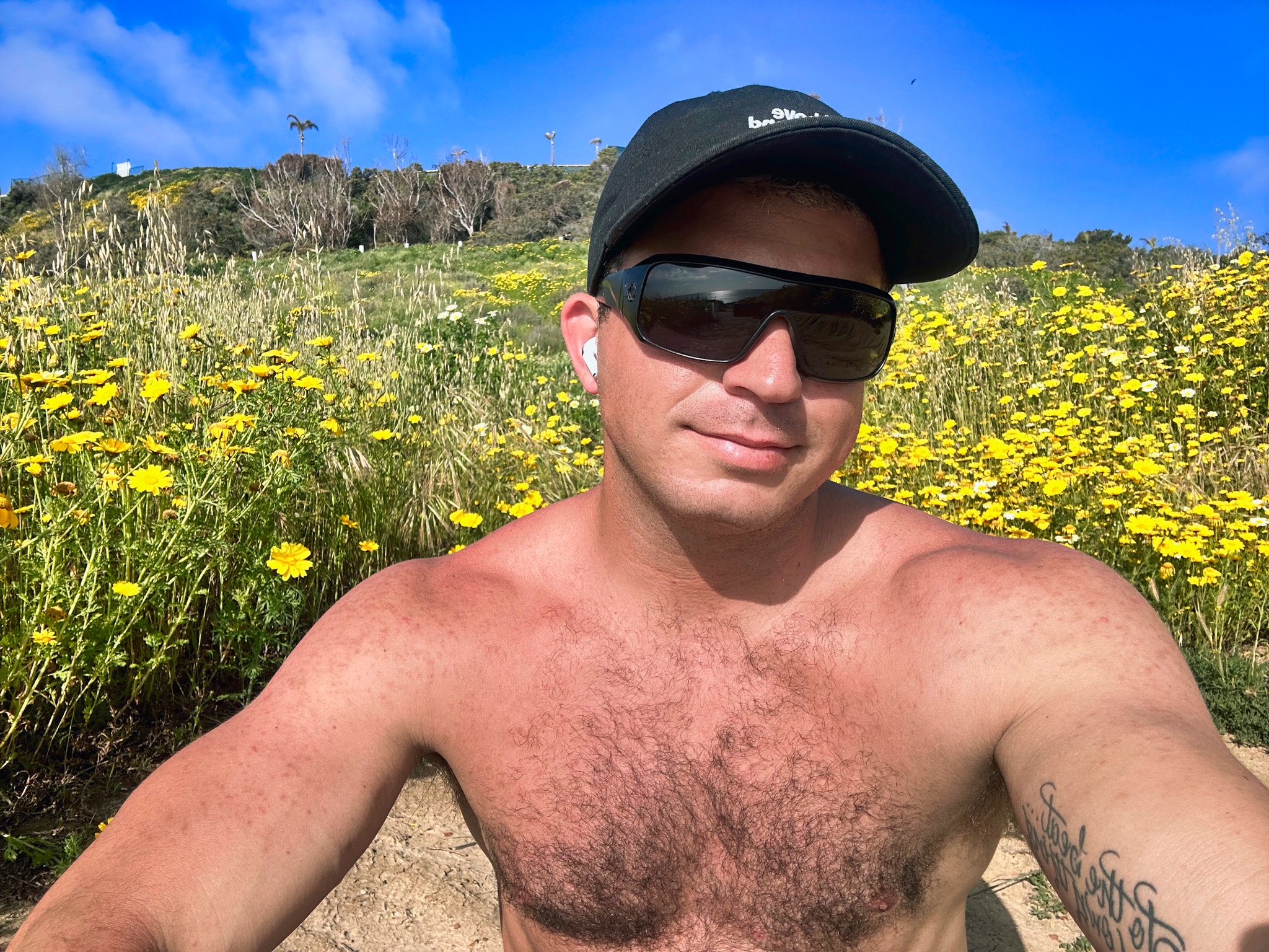 Hermz Shamoun standing in a field of yellow wildflowers